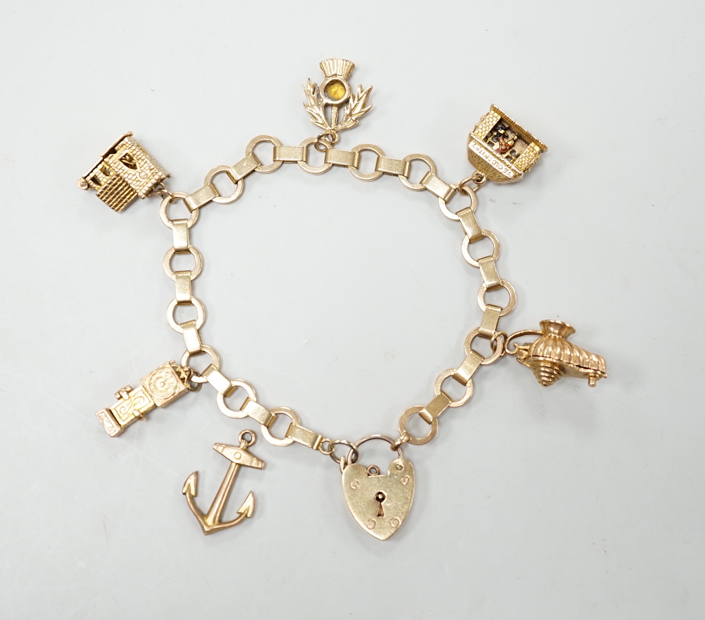 A 1950's 9ct gold charm bracelet hung with six assorted charms, gross weight 25.5 grams.